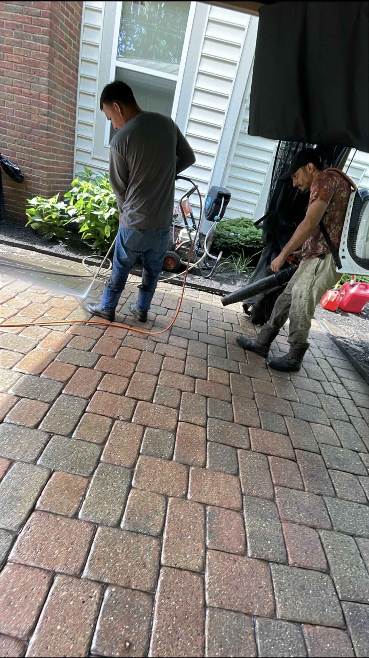 Impact Pro crew pressure washing a residential paver patio